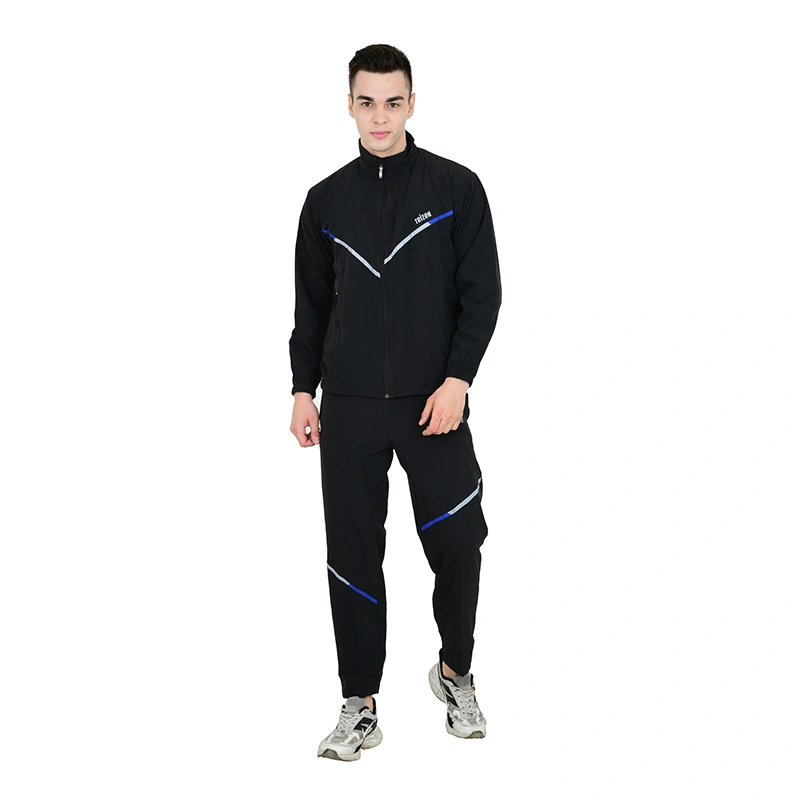 Male model in black tracksuit with blue and silver stripe accent and grey sneakers - menswear ecommerce photography by Lohar Studio Delhi